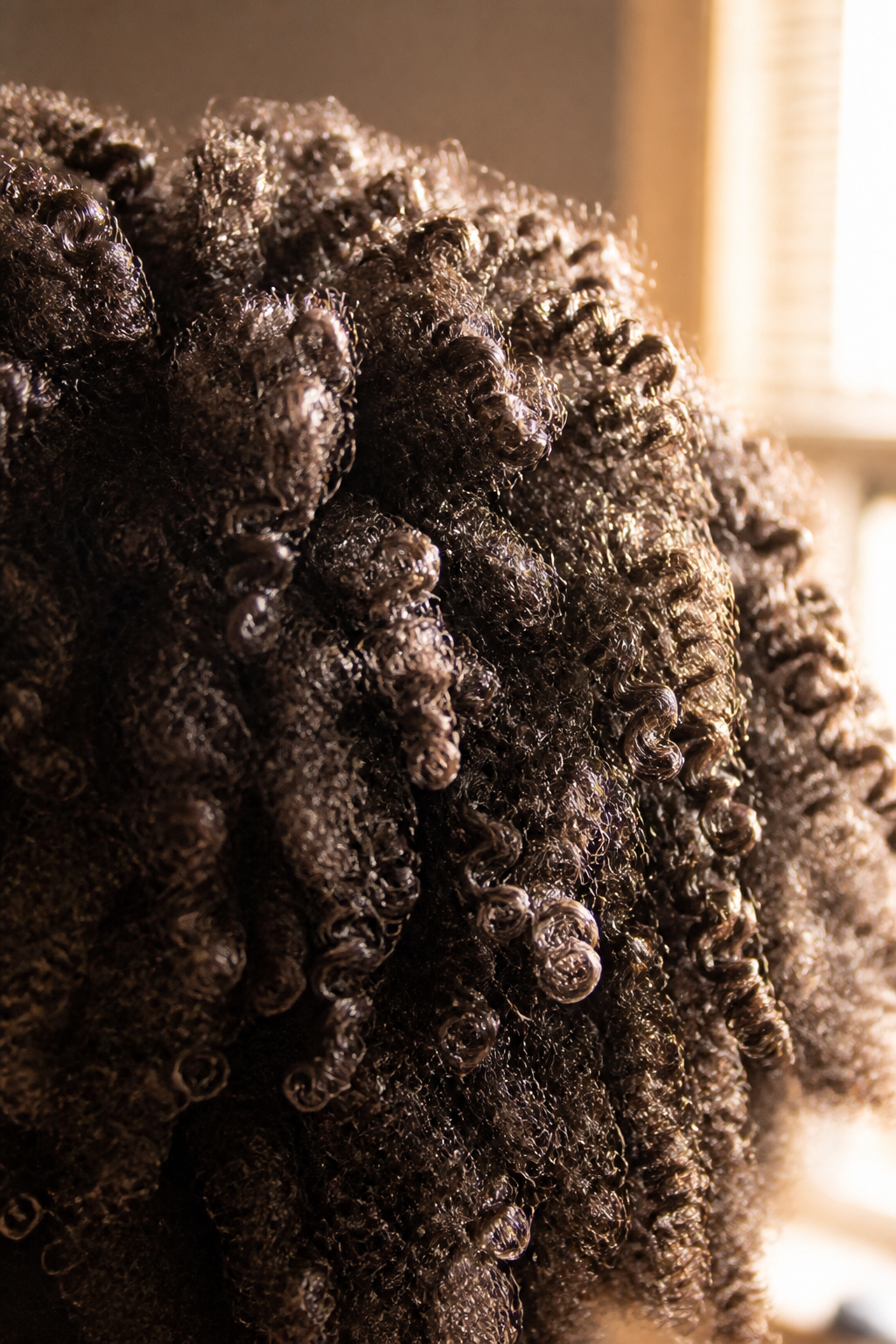 Cachos 4C com leave-in nas coils, contraluz. Direção de arte — sem likeness.